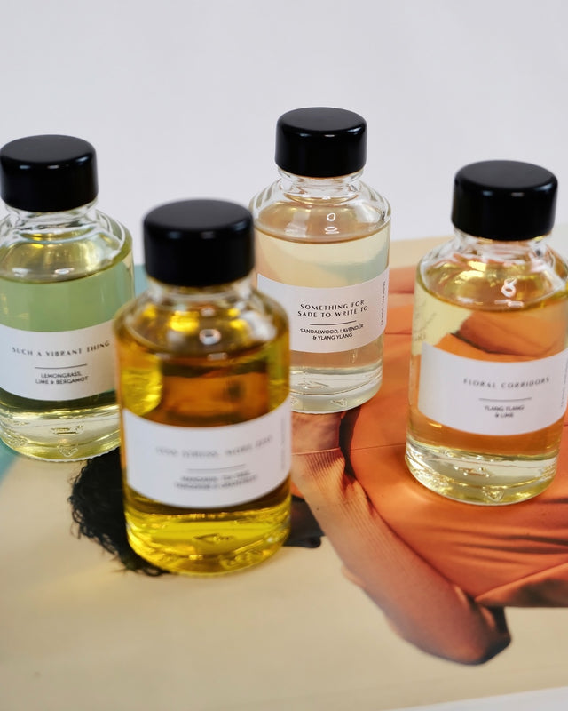 Luxury home fragrance discovery set styled on a design magazine, highlighting minimalist white labels and black caps.