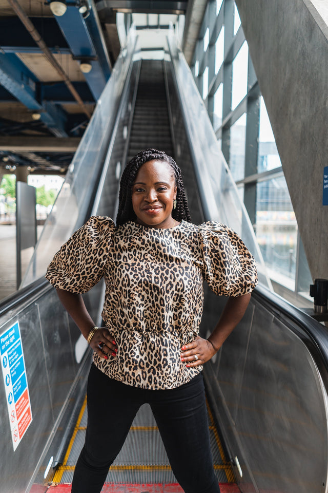 Award-winning entrepreneur Ronke Lawal posing in a bright, modern setting, representing the balance between professional success and personal wellness.